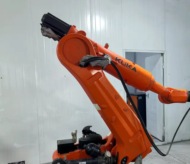 Orange KUKA robot used for automated handling in a manufacturing cell